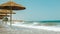 beach with reed umbrellas on the Mediterranean coast in Crete