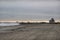 Beach replenishment on a wide sandy beach with construction vehicles and a large pipeline