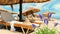 Beach  resort white sand lilac blue flowers straw women hats awnings umbrellas blue sky wooden tables sun loungers Mediterranean S