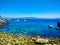 Beach of rocks in Cies Islands, Galicia, Spain, with boats diving in front of it