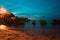 Beach with rocks and night lights. The idyllic concept