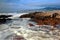 Beach with rocks, waves stream and fog