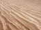 Beach sand pattern closeup, fine rippling sand background