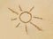 Beach sand surface with simple sun drawing