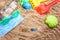 Beach sand with toys for the baby, water, the word summer in colored letters