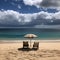 beach scene with two chairs and an umbrella perched on the golden sand