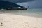 Beach and sea with boats over cloudy sky