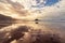 Beach and sea landscape with rocks, reflections in the sand, very cloudy sky with intense fog