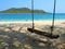 Beach with sea, mountain, sands, and swing in sunny photo. Traveler are happy on vacation in the Ocean. It is Samae San Island.