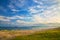 A beach on the sea, sand and waves, seagulls fly over the water.