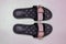 Beach shoes. Close-up of a pair modern black pink ladies rubber bathing sandale isolated on a white background. Topview