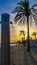 Beach shower on sandy beach on the background of sunset and palm trees