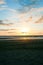 Beach in silhouette as sunsets on distant horizon