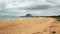 Beach with single hill Patanangala rock in distance on overcas