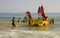 Beach staff and Holiday makers in hired Pedalos fight against the incoming surf to get out into calmer water at the beach in Albuf