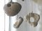 Beach stones with holes hanging on pieces of white twine in a window