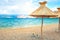 Beach straw umbrellas lounger chair with sand and clear water