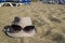 Beach in summer. On the sand lies a woman`s hat with glasses.