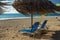 Beach sun beds and straw umbrella on Milos beach on Lefkada island, Greece -