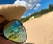 Beach with sun umbrellas and chair lounges reflection in woman sunglasses sitting on the beach at summer