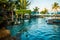 Beach sunbeds near swimming pool in tropical resort with palms during sunset, Gili Trawangan, Lombok, Indonesia