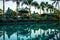 Beach sunbeds near swimming pool in tropical resort with palms during sunset, Gili Trawangan, Lombok, Indonesia