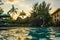 Beach sunbeds near swimming pool in tropical resort with palms during sunset, Gili Trawangan, Lombok, Indonesia