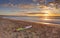 Beach sunrise and paddleboard on shoreline