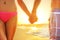 Beach sunset couple in love holding hands romantic