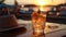 beach sunset,glass of sparkling orange water on wooden table top on beach