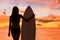 Beach sunset sexy surfer woman surfing lifestyle relaxing holding surfboard looking at ocean waves for surf. Active