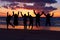 Beach, sunset and silhouette of jumping friends in nature, freedom and celebrating travel outdoor. Shadow, jump and