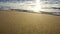 Beach at sunset, waves rushing towards golden beach, sunset reflection on water