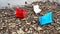 On the beach - three colorful paper boats on a stone dune near of beautiful azure sea or river on a sunny day