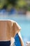 Beach towel in cream color hung on the empty deck chair by the s