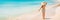 Beach Travel Vacation Holidays Woman Relaxing walking on idyllic Caribbean beach panorama banner background. Rear view