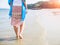 Beach travel - woman walking on sand beach. Closeup detail of female feet