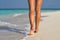 Beach travel - woman walking on sand beach leaving footprints in