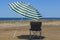 Beach umbrella and folding chair on the beach