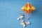 Beach umbrella model and sea shells on blue background. Tropical sea vacation and holiday.