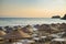 Beach umbrellas and chaise lounges with sea and evening sky in the background.