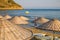 Beach umbrellas and chaise lounges with sea and sky in the background