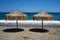 Beach umbrellas made of palm leaves on the beach of the Aegean Sea