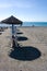 Beach umbrellas on the sand at the Costa del Sol resort of Nerja
