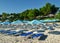 Beach. Umbrellas and sun beds without people. Green trees in the background Greece. Kassandra. Halkidiki