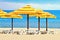 Beach umbrellas and sunbath seats on sand beach
