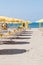 Beach umbrellas and tourists enjoying beach facilities at Lido Di Ostia, Italy on a sunny summer day