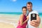 Beach vacation couple taking selfie on smartphone