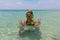 Beach vacation fun woman wearing a snorkel scuba mask making a goofy face while swimming in ocean water. Closeup