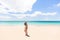 Beach vacation paradise Hawaii tourist woman walking on white sand wide perfect beach summer holiday in the Caribbean